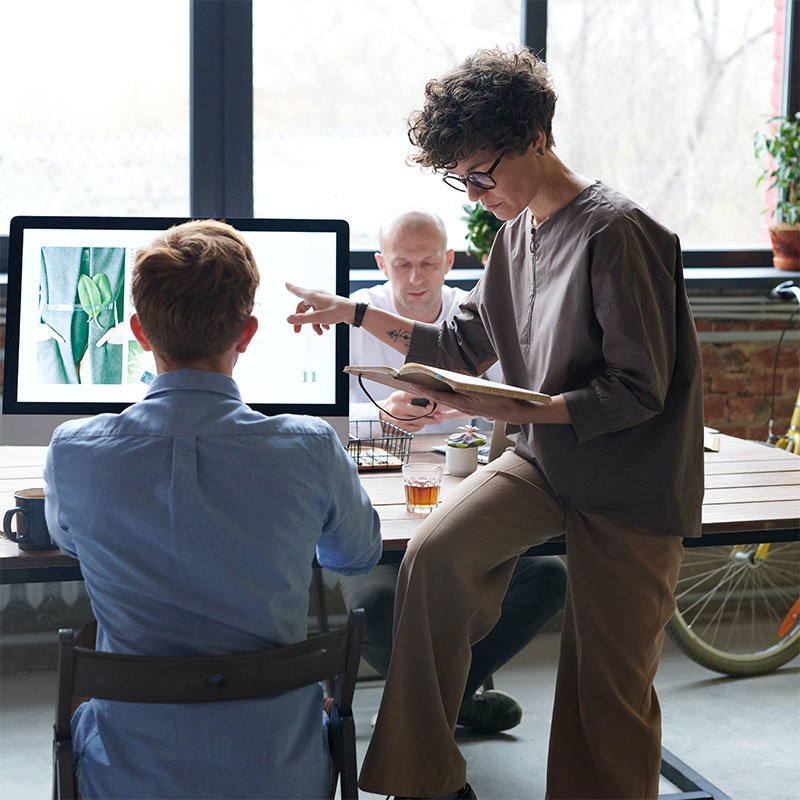 Team collaborating around a computer, symbolizing SEO strategy and support for small businesses and nonprofits