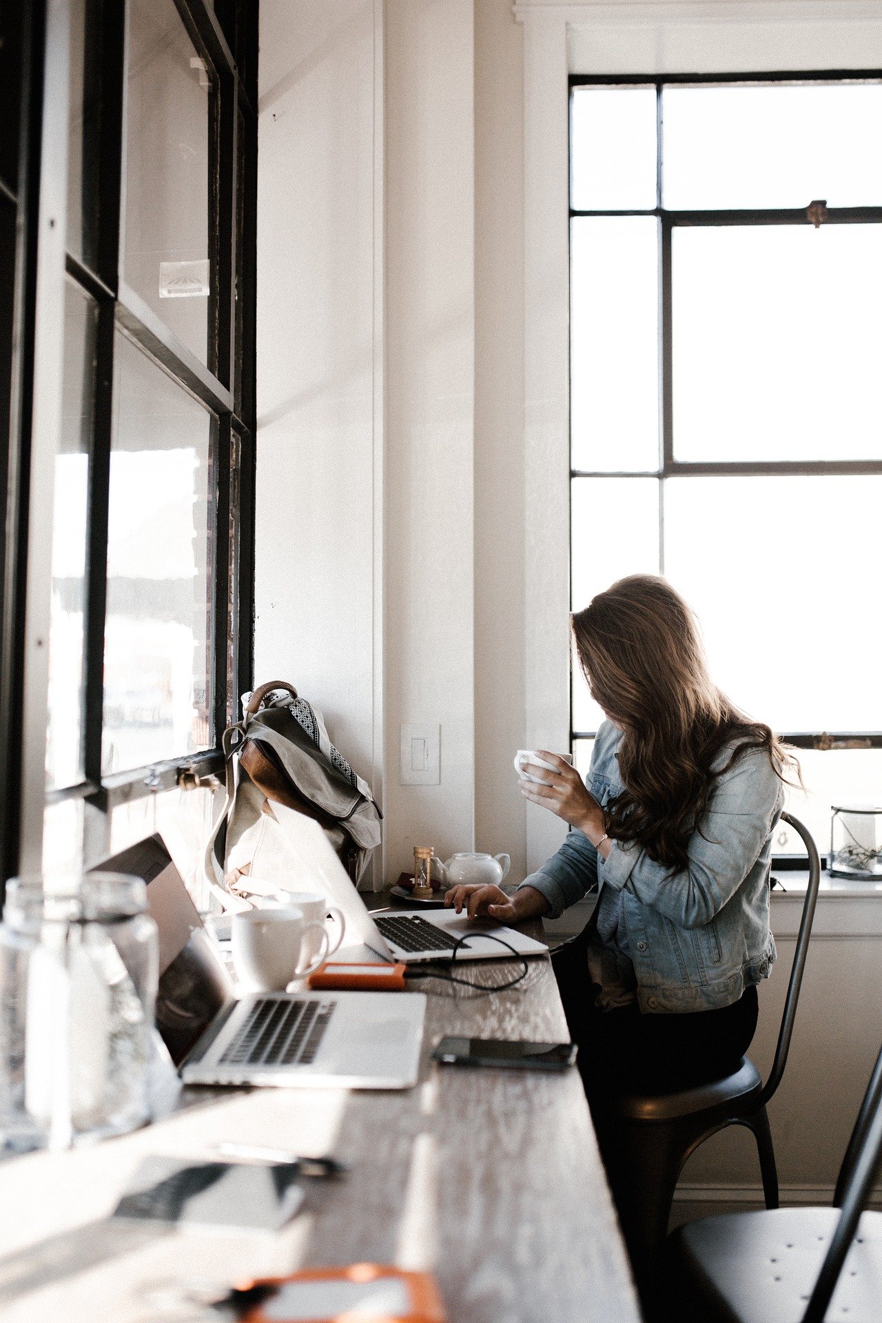 Woman working on laptop in coffee shop, symbolizing accessible SEO support for small businesses and nonprofits